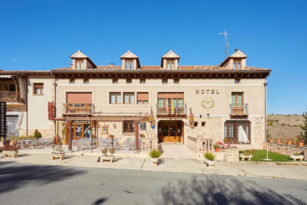 a large white building with a courtyard in front of it at Hotel Puerta Sepúlveda in Sepúlveda