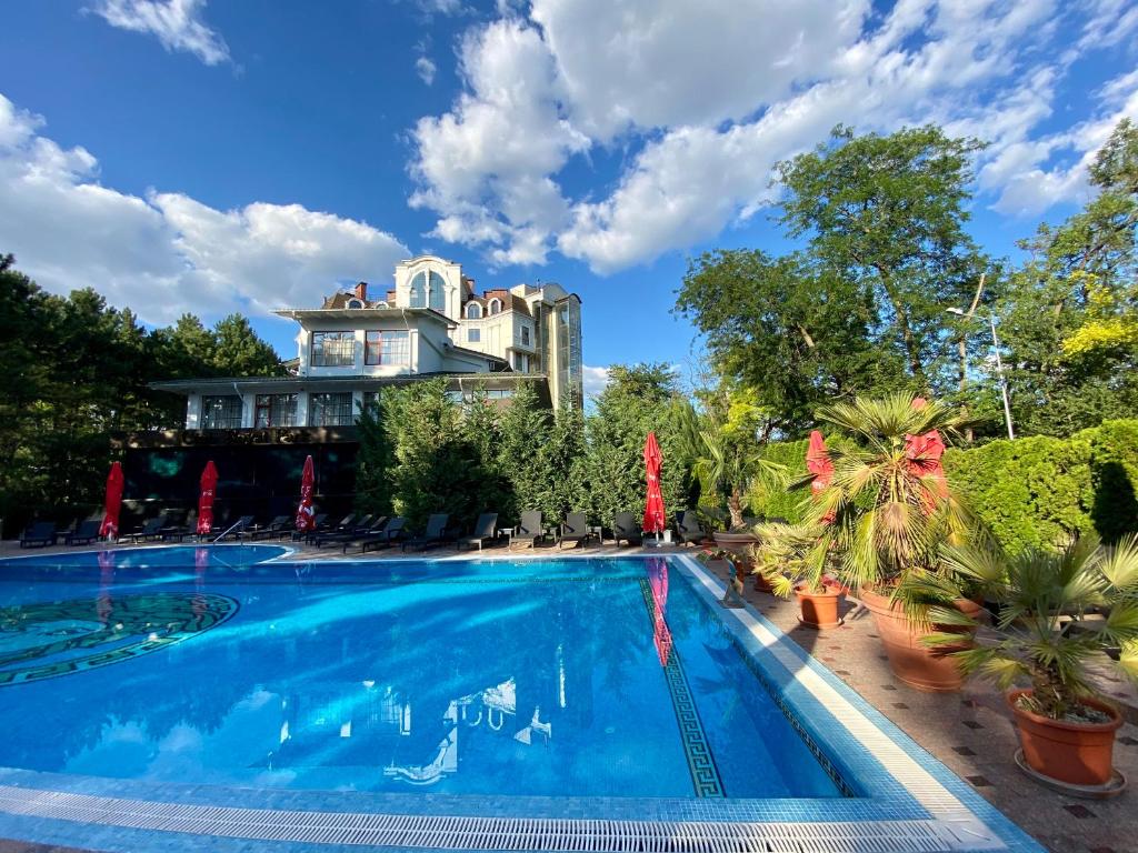 a large swimming pool in front of a house at Hotel Royal Park in Chişinău