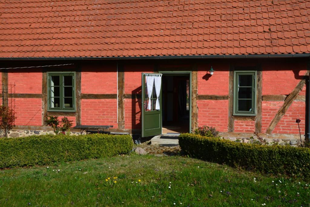 una casa in mattoni rossi con una porta verde di Alte Ausspanne FEWO a Walkendorf