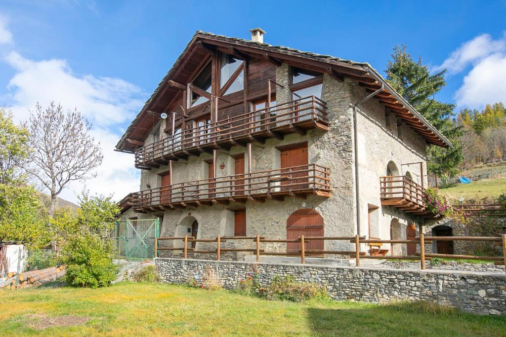 an old house with wooden balconies on top of it at Romito Lodge Apartment Mountain Retreat - Happy Rentals in Cesana Torinese