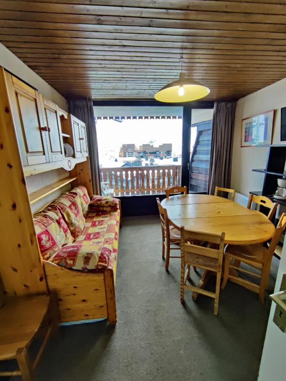 a living room with a table and a couch and a table and chair at ski-in ski-out 52 in Val Thorens