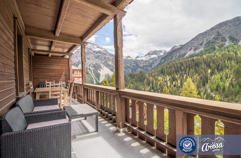 a balcony with chairs and a view of mountains at Weisshorn Apartment by Arosa Holiday in Arosa