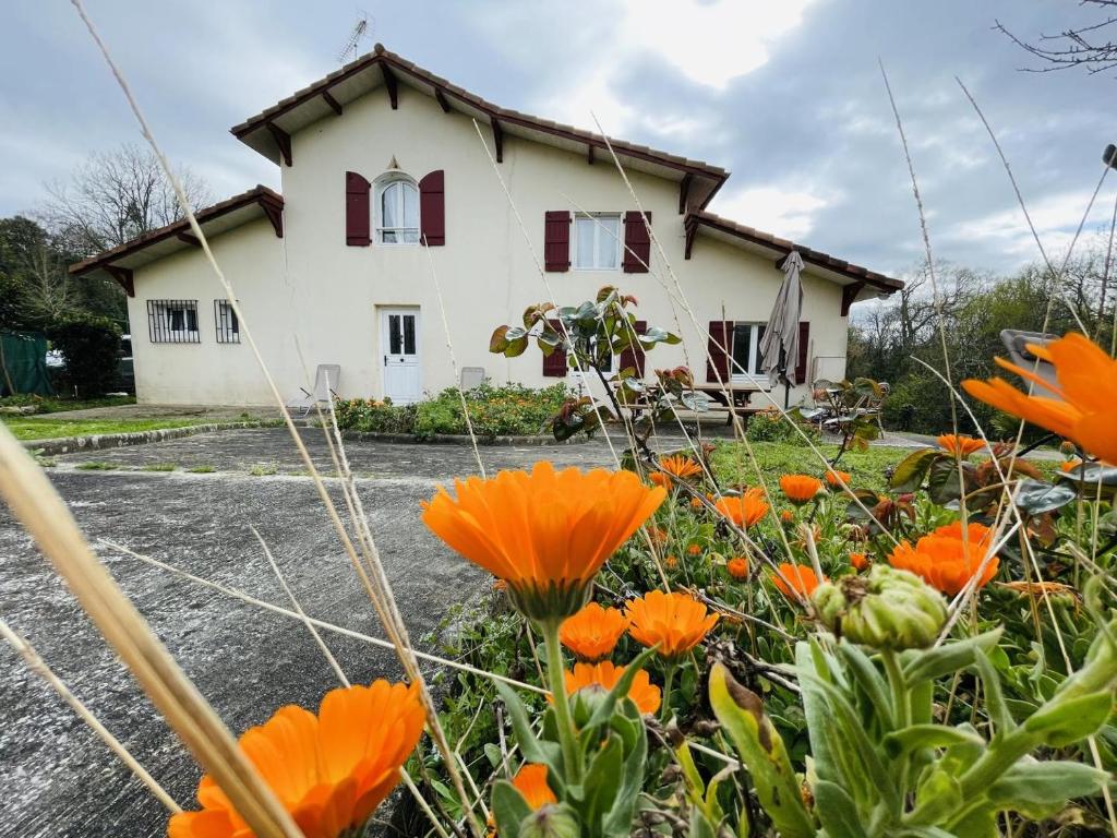 una casa con flores naranjas delante de ella en Gite turon, en Saint-Sever
