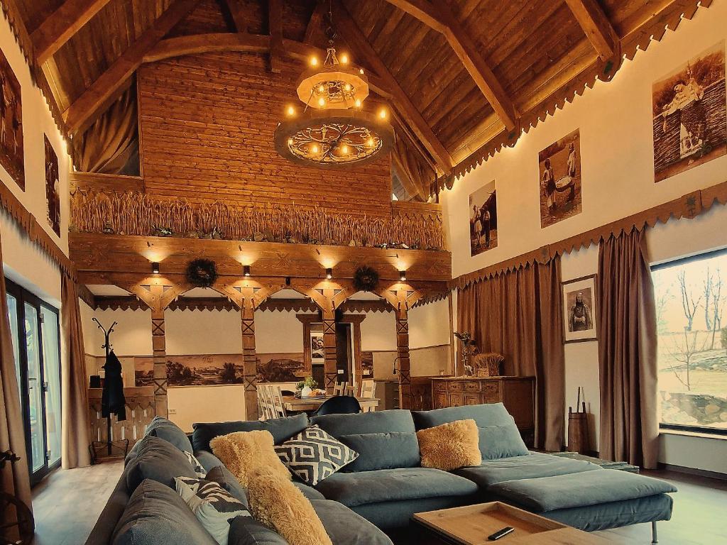 uma sala de estar com um sofá e um lustre em Plai din Bran em Bran