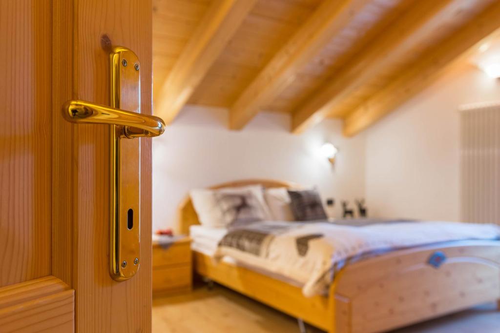 ein Schlafzimmer mit einem Bett in einem Zimmer mit einer Tür in der Unterkunft Casa Rossetti Big in Pozza di Fassa