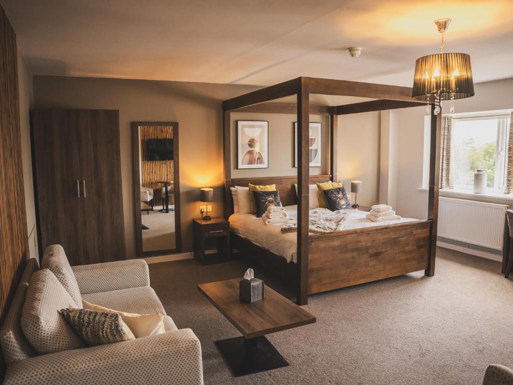 een slaapkamer met een hemelbed en een woonkamer bij Crossways in Wells