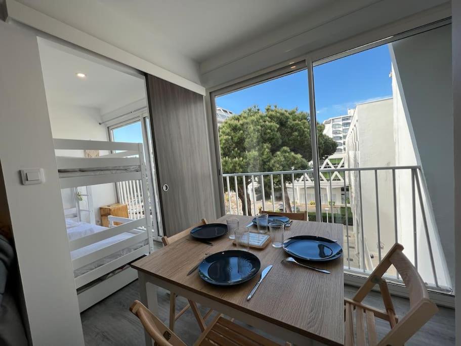une salle à manger avec une table et une grande fenêtre dans l'établissement Le Palais MAYA - Lumineux - Wifi, à La Grande Motte