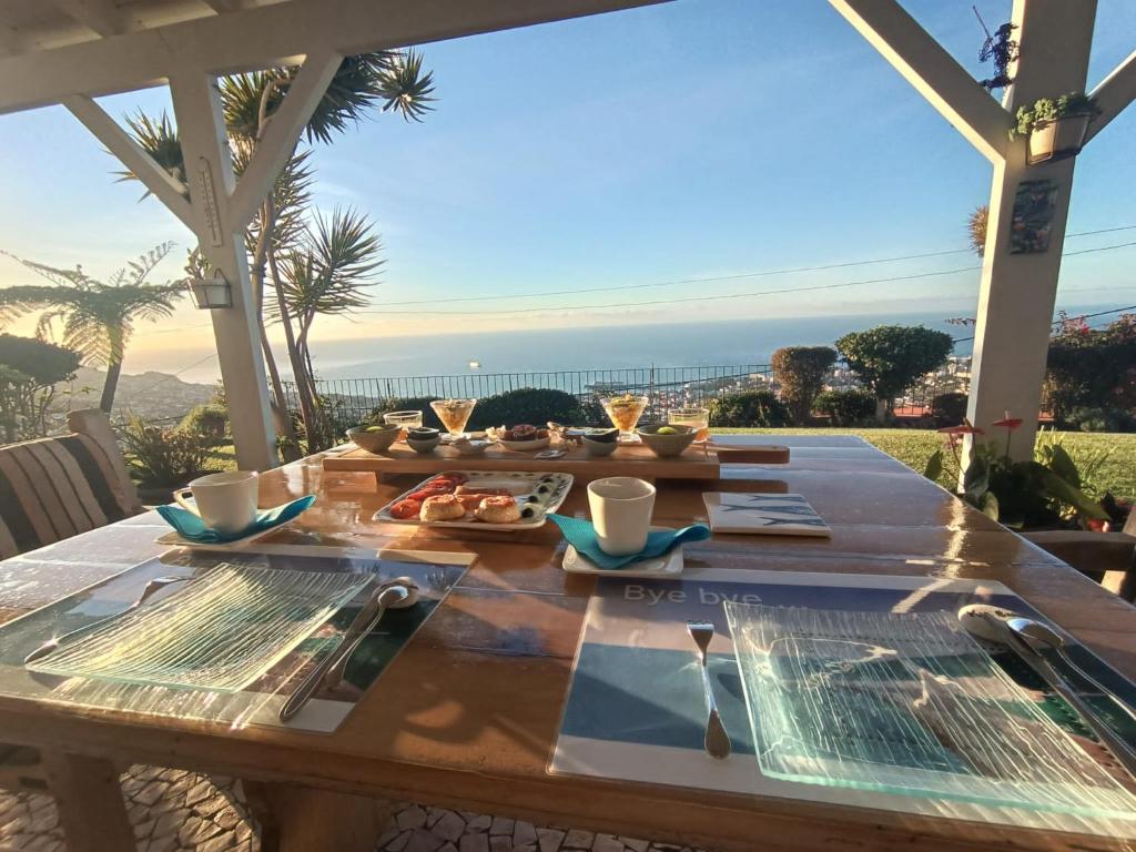 uma mesa com comida e vista para o oceano em La Chambre de Ker Briac no Funchal