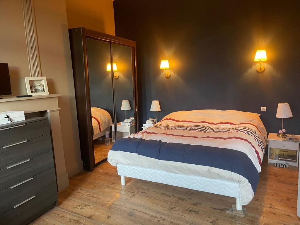 een slaapkamer met een bed, een dressoir en een spiegel bij Le gite berguois in Bergues