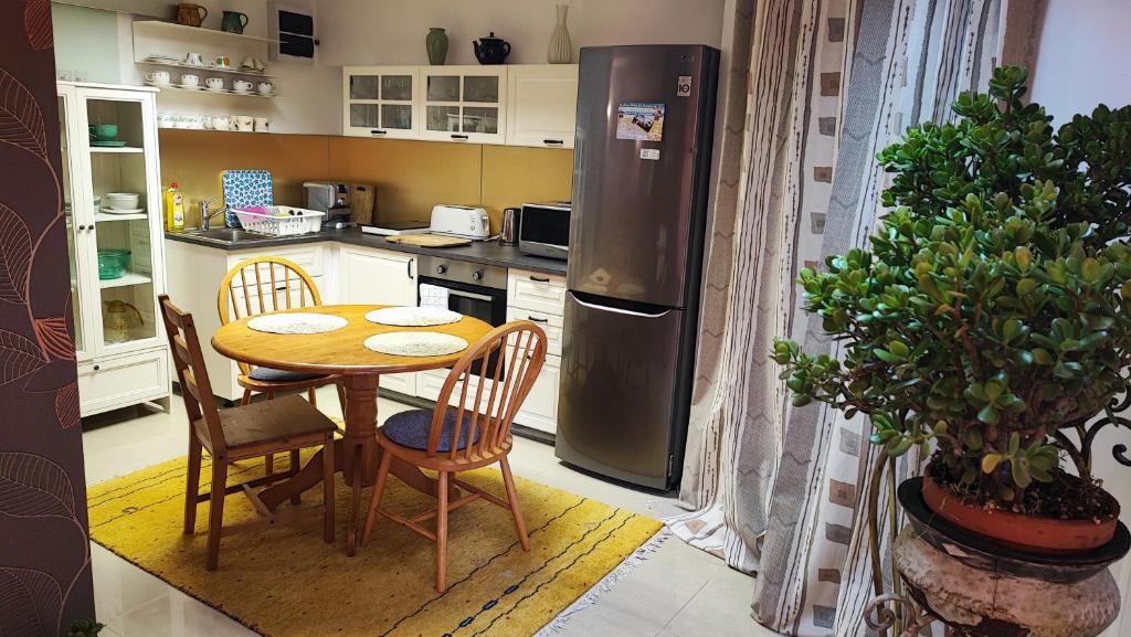 a small kitchen with a table and a refrigerator at Andy's Apartman in Budapest