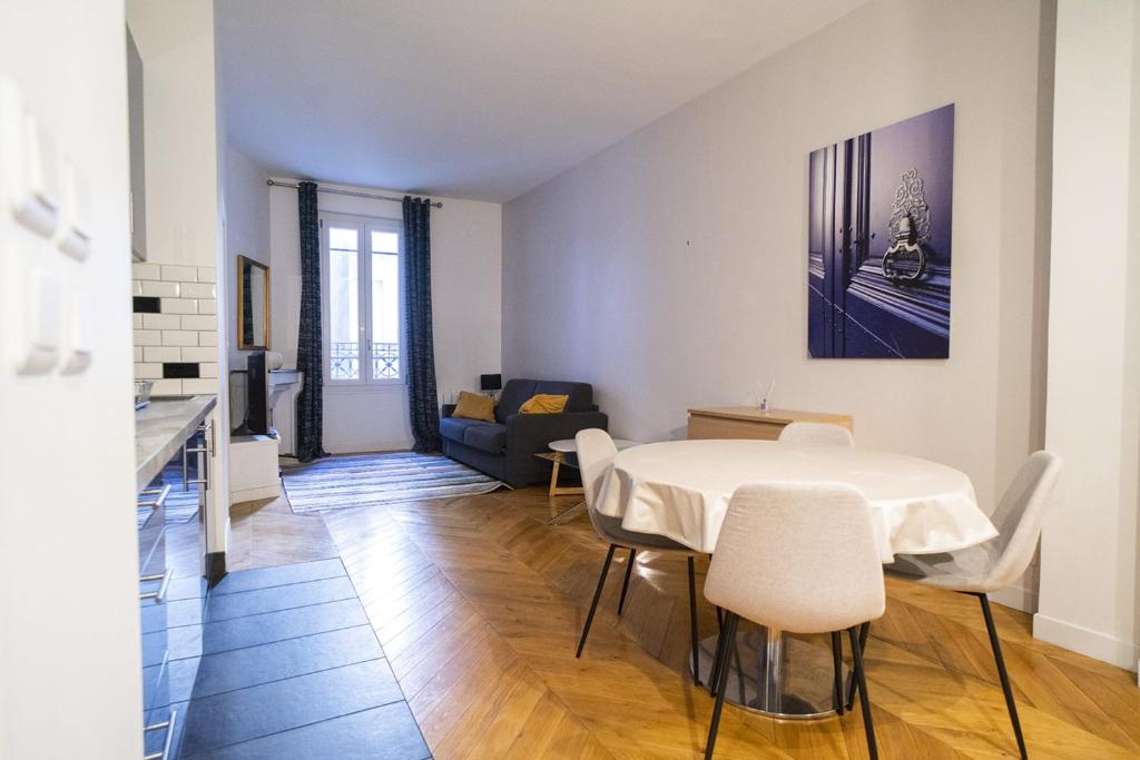 un salon avec une table et des chaises blanches dans l'établissement Apartment near Montmartre, à Paris