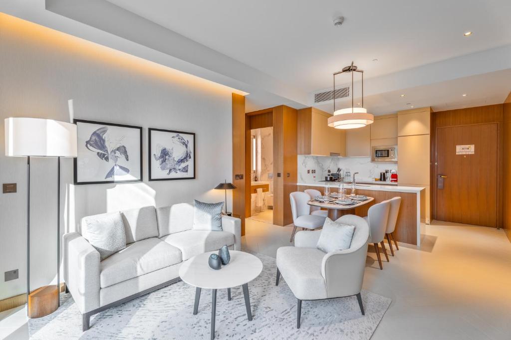 ein Wohnzimmer mit weißen Möbeln und eine Küche in der Unterkunft EasyGo - Address Opera Residences T2 -1 Bedroom in Dubai