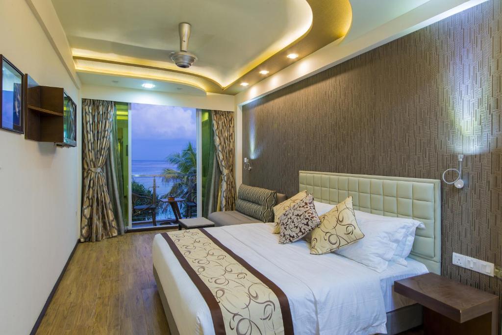 a hotel room with a bed and a balcony at Vista Beach Retreat in Hulhumale