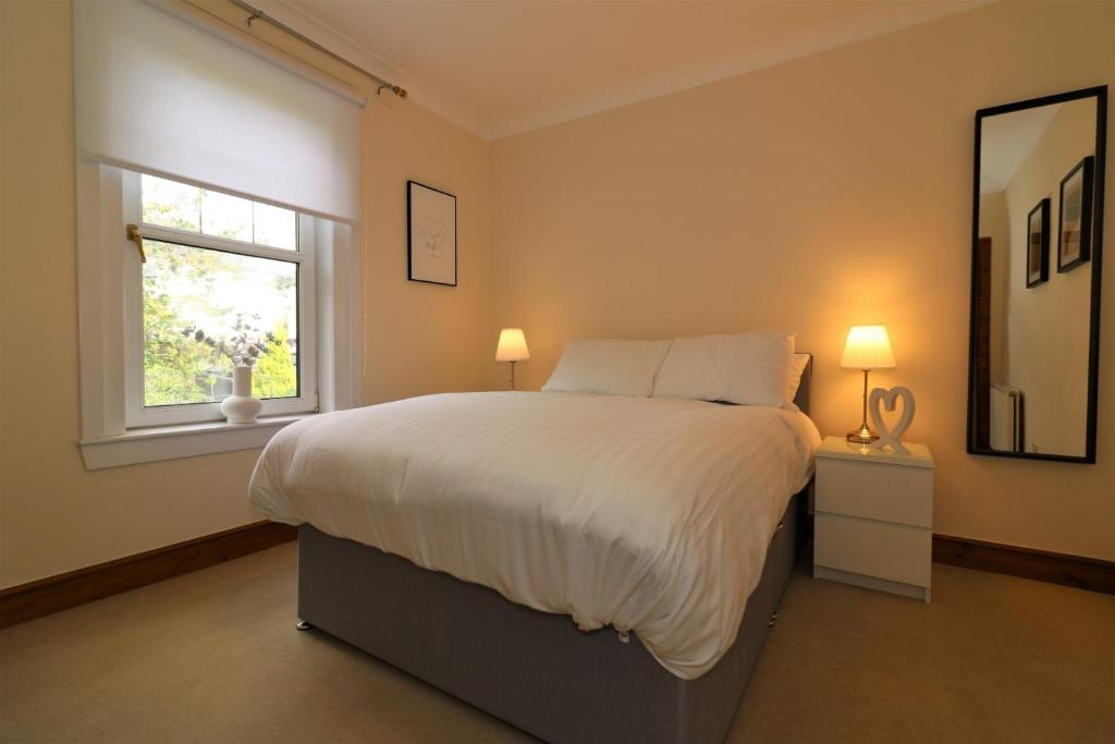 a bedroom with a large bed and a window at Signature - Lincoln View in Knightswood