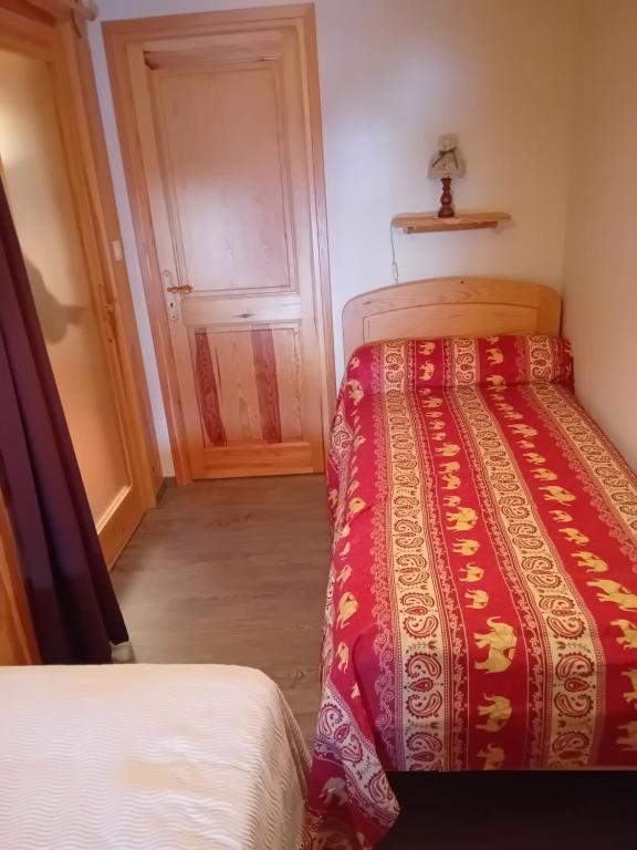 1 Schlafzimmer mit 2 Betten in einem Zimmer mit einer Tür in der Unterkunft gite de la butte aux oiseaux in Saint-Alban-sur-Limagnole