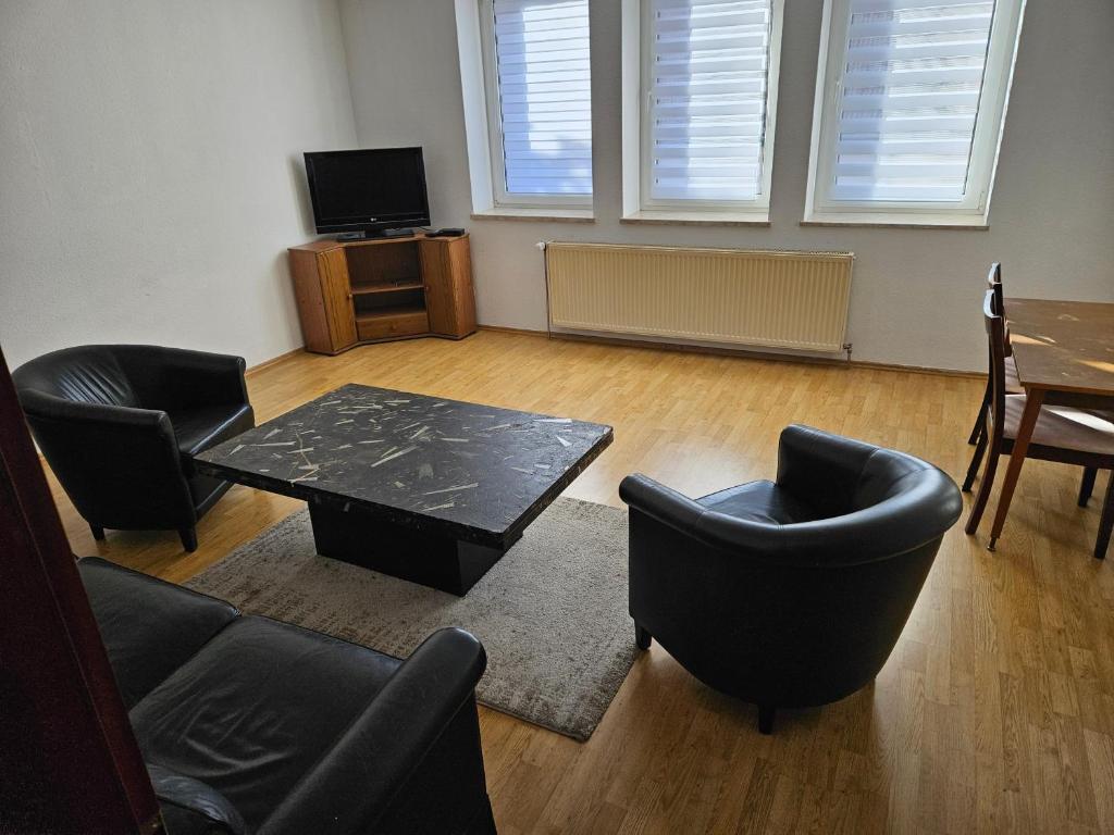 a living room with chairs and a table and a tv at FeWo3 Köthen 