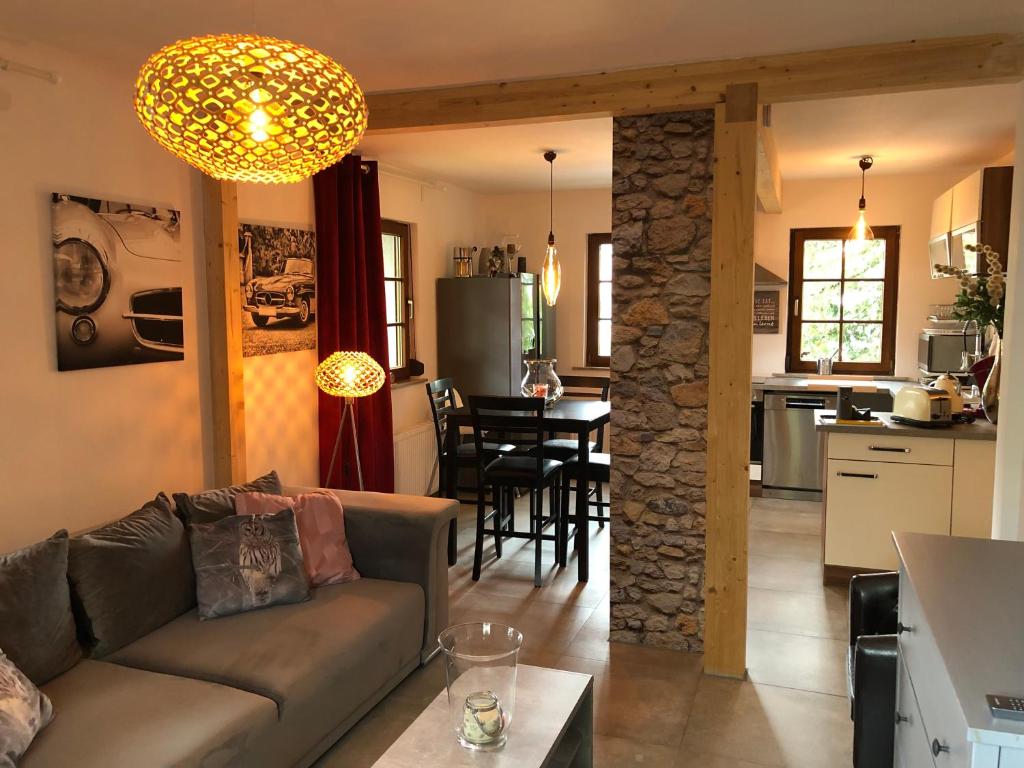 a living room and kitchen with a couch and a table at Willkommen im Casa Felice, der Wohlfühl Oase mit Balkon, 4 Betten und Homeoffice Platz in Aidlingen