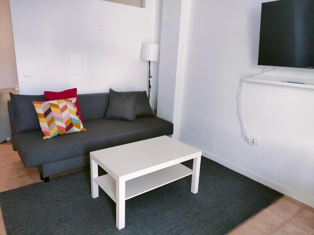 a living room with a couch and a table at San Centro IFEMA Wizink Metropolitano Airport Apartments in Madrid
