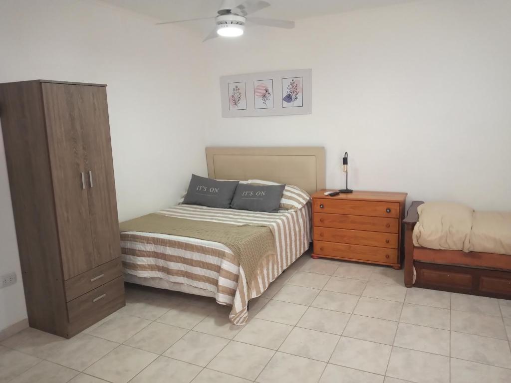 1 dormitorio con cama y tocador de madera en Monoambientes Arandu en Federación