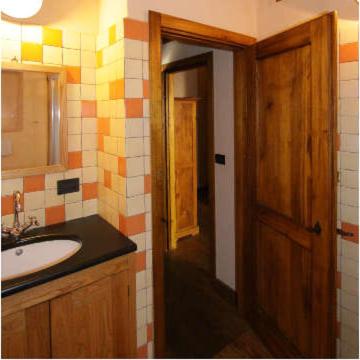 a bathroom with a sink and a wooden door at Agririfugio Molini in Camogli