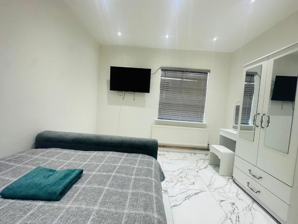 a bedroom with a bed and a flat screen tv at KNIGHTSBRIDGE COURT in Horninglow