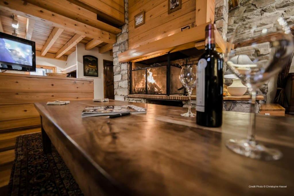 a bar with a bottle of wine and two glasses at Joli Chalet Savoyard in Val-d'Isère