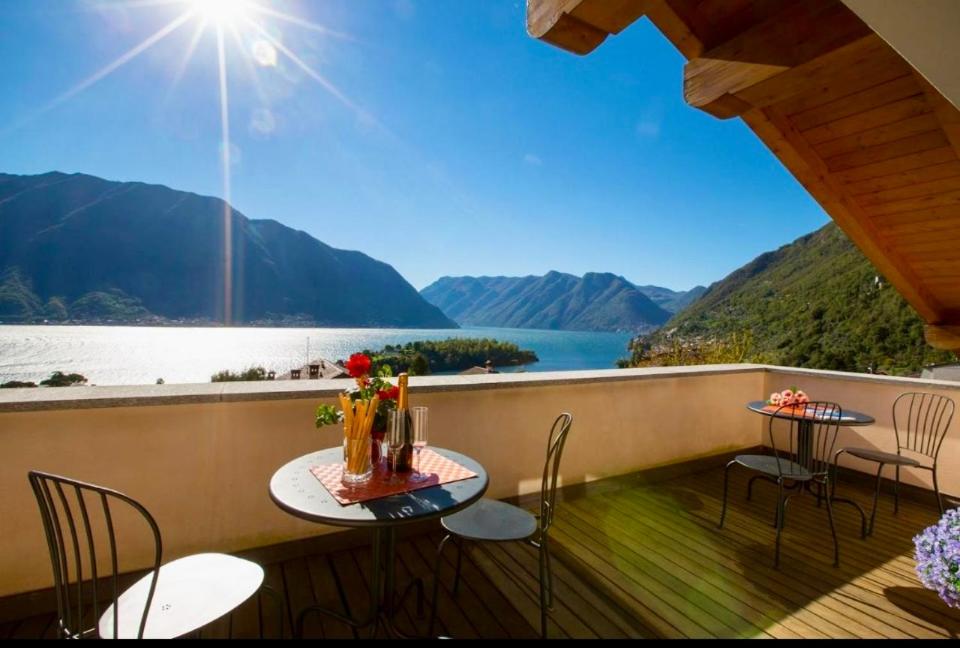 a balcony with a table and chairs and a view of the water at La Bella Ossuccio in Ossuccio