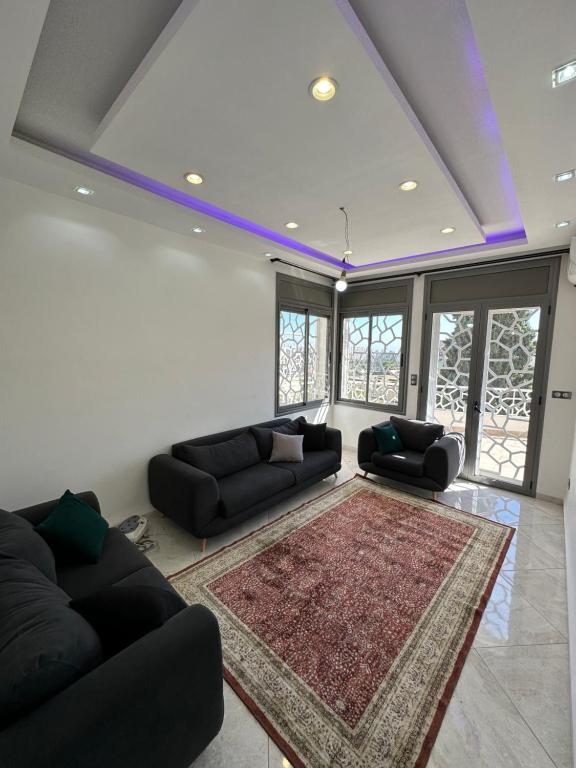 una sala de estar con 2 sofás y una alfombra en maison luxe à HYDRA F6, en Argel