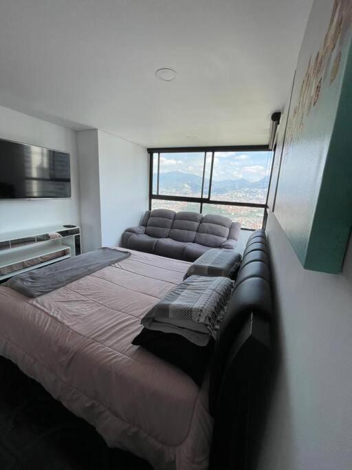 1 dormitorio con 1 cama grande y 1 sofá en Apto de lujo Las Palmas medellin 3 BR, en Medellín