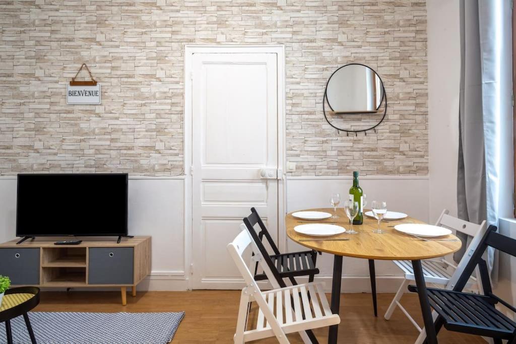 une salle à manger avec une table et une télévision dans l'établissement Appart Cosy 2 chambres 6 personnes RER A 15 min, à Champigny-sur-Marne