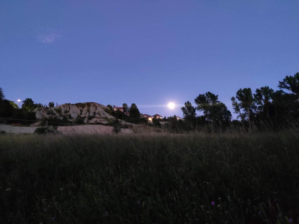 um campo de relva com a lua no céu em Agriturismo Munarin Caterina em Mioglia