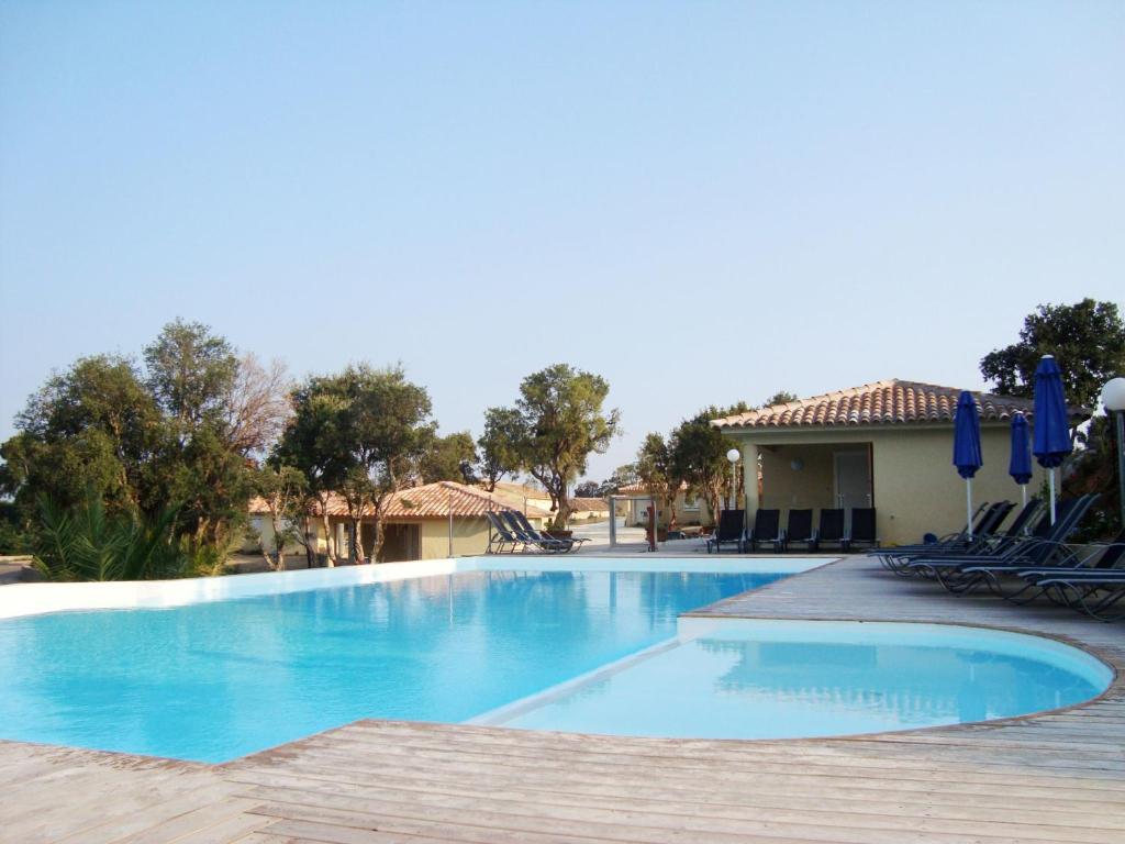 een zwembad in een resort met stoelen bij Résidence Odalys San Martinu in Sainte-Lucie de Porto-Vecchio