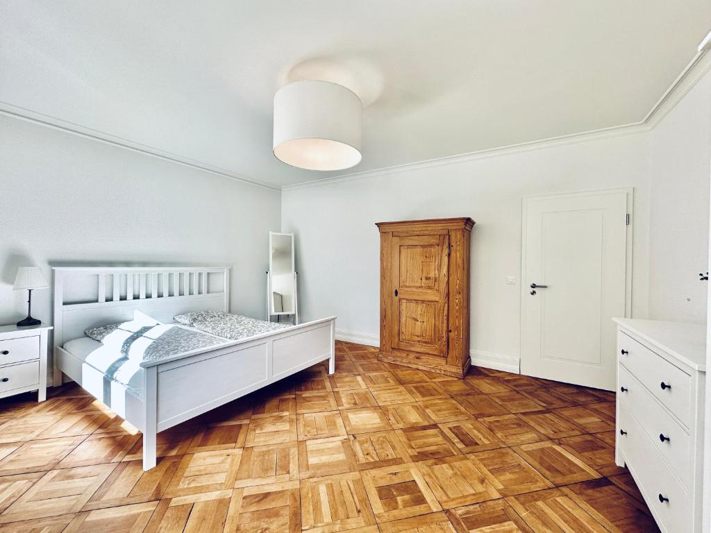 1 dormitorio con 1 cama y suelo de madera en Business Apartment ZIMMERzuVERMIETEN in Solothurn, en Solothurn