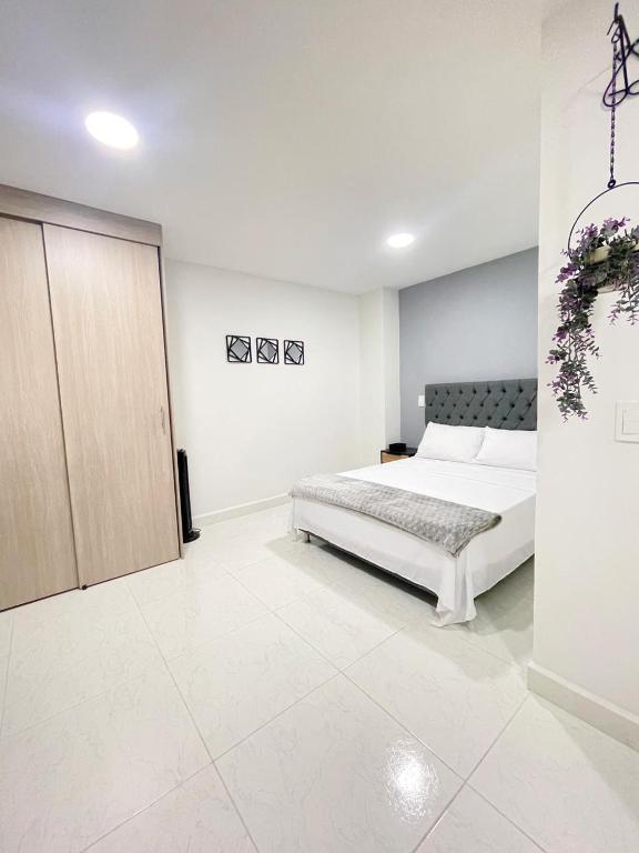 una camera bianca con letto e armadio di Sabaneta Central Nómadas digitales Wi-Fi 202 a Sabaneta