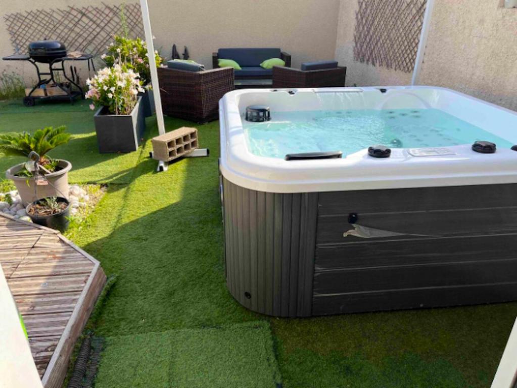 a hot tub sitting on the grass in a backyard at Maison de 3 chambres a Valras Plage a 600 m de la plage avec spa jardin clos et wifi in Valras-Plage