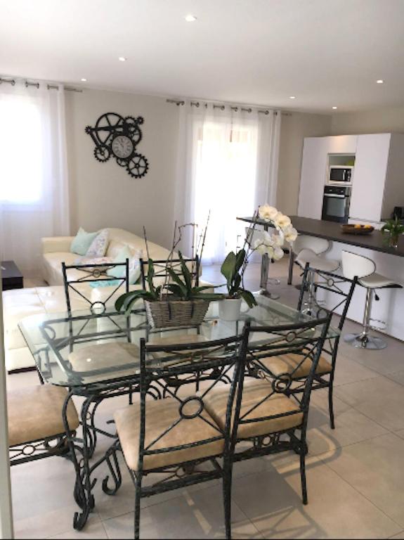 a living room with a glass table and chairs at Maison de 3 chambres a Valras Plage a 600 m de la plage avec spa jardin clos et wifi in Valras-Plage