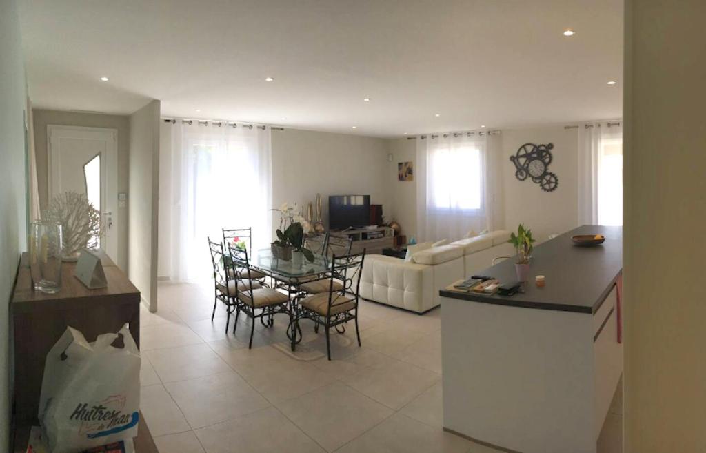 a kitchen and living room with a table and a couch at Maison de 3 chambres a Valras Plage a 600 m de la plage avec spa jardin clos et wifi in Valras-Plage