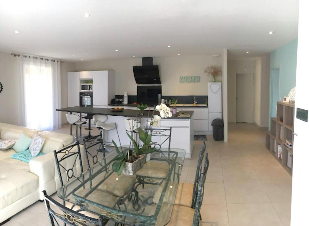 a kitchen and living room with a table and chairs at Maison de 3 chambres a Valras Plage a 600 m de la plage avec spa jardin clos et wifi in Valras-Plage