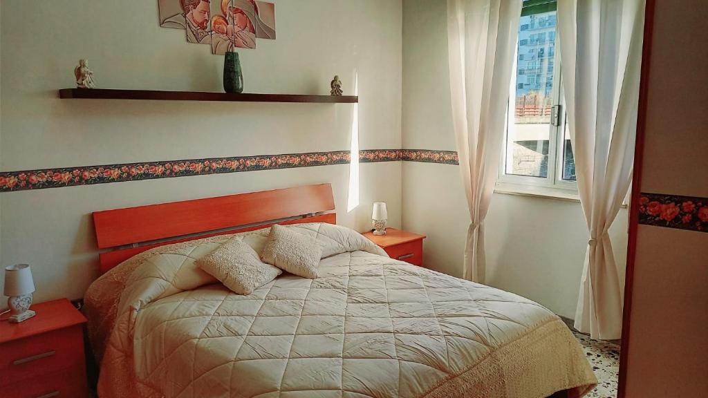 Un dormitorio con una cama con dos almohadas y una ventana. en LG HOUSE casa vacanze, en Nápoles