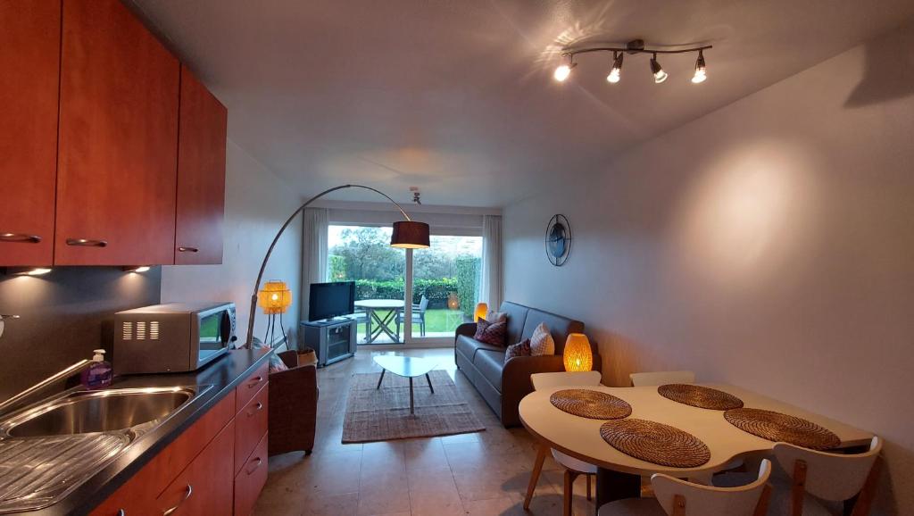 a kitchen with a table and a living room at Residentie Koksijde promenade in Koksijde