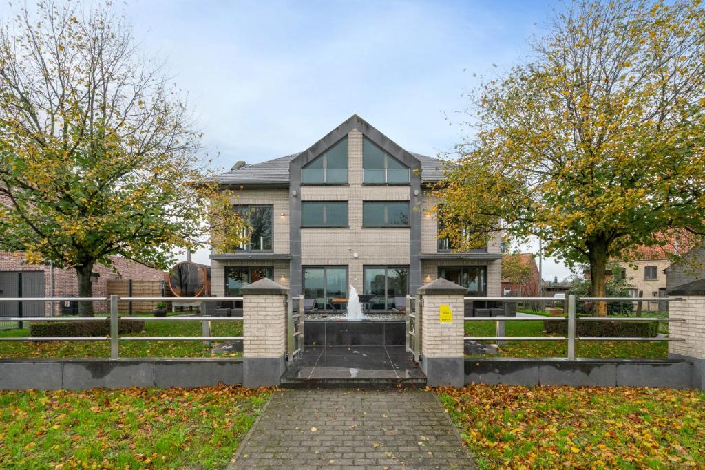 a house with a fence in front of it at J and R flanders fields holiday homes in Diksmuide