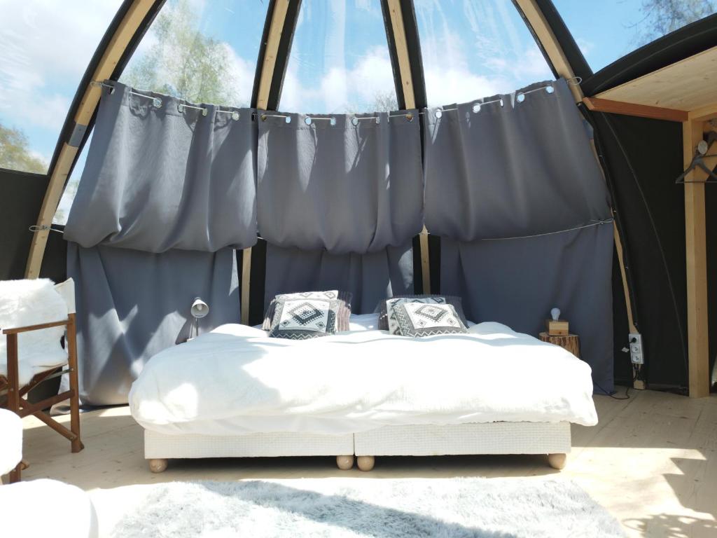 een slaapkamer met een bed in een tent bij Bulle nuage - Etat Nature in Magnières
