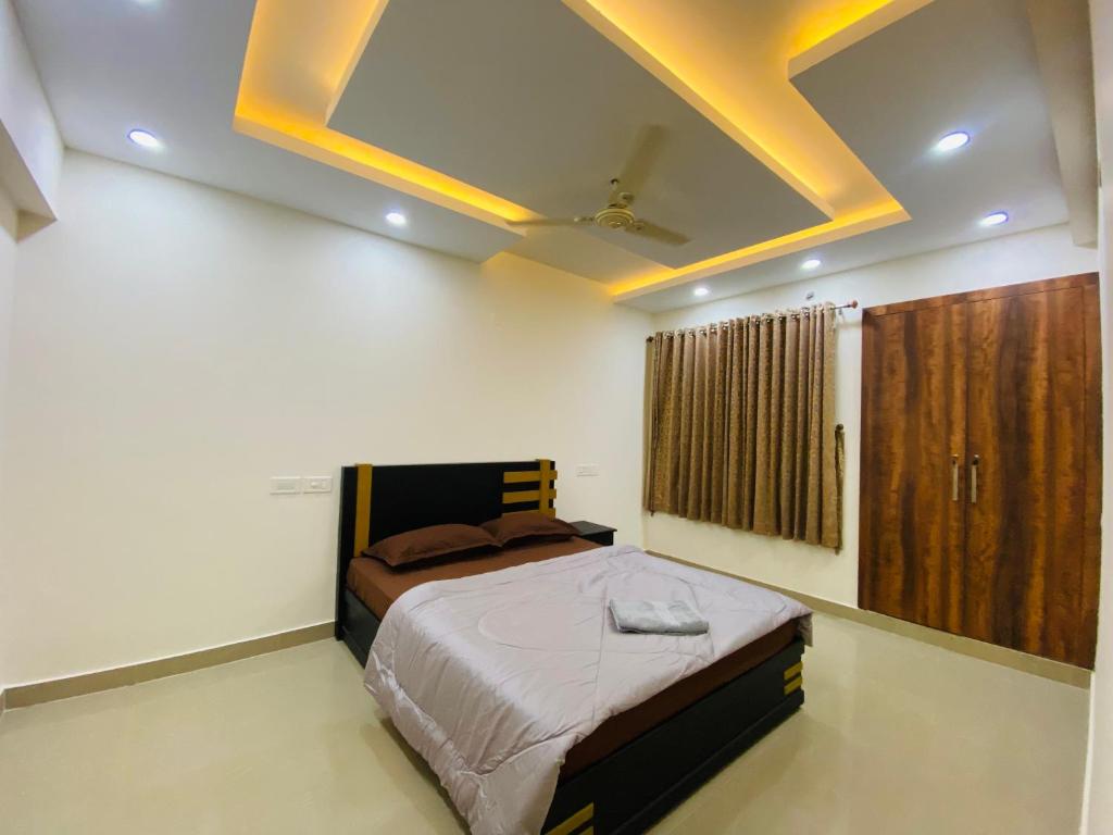 um quarto com uma cama e um tecto amarelo em AL-Kabeer Heights em Kazhakuttam