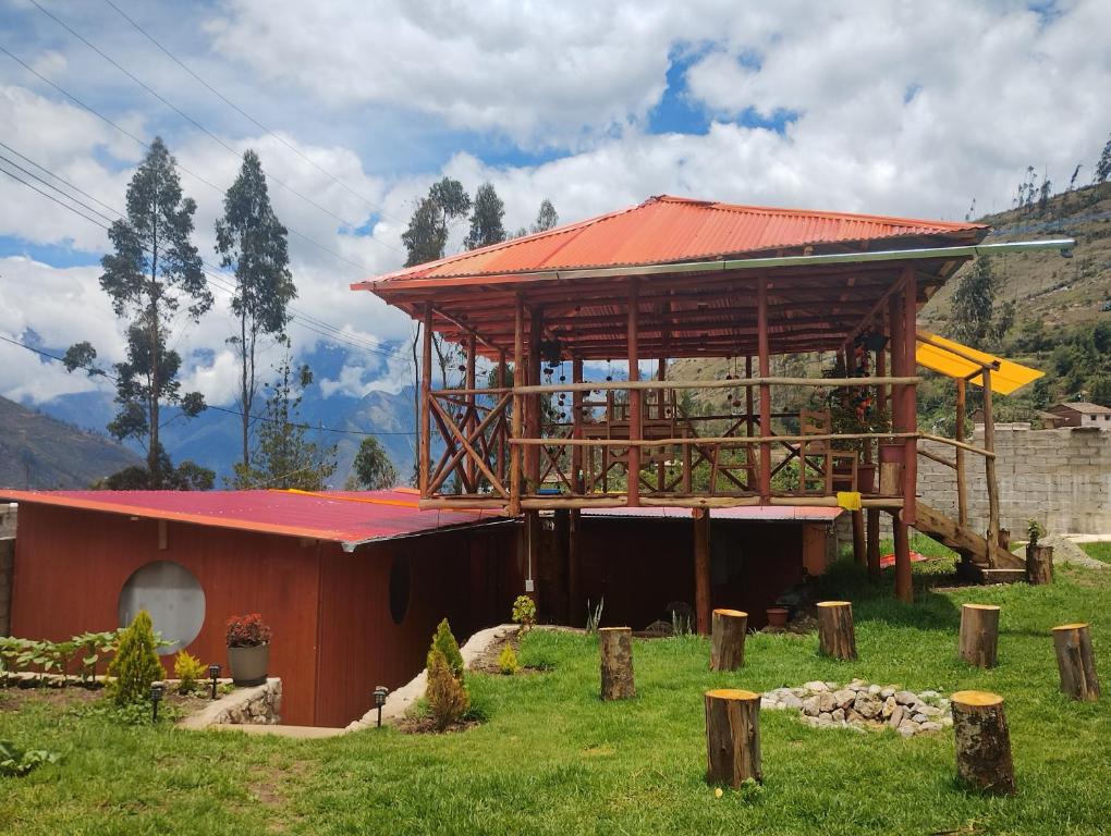 een klein gebouw met een rood dak in een veld bij the wooden house choquequirao in Cachora