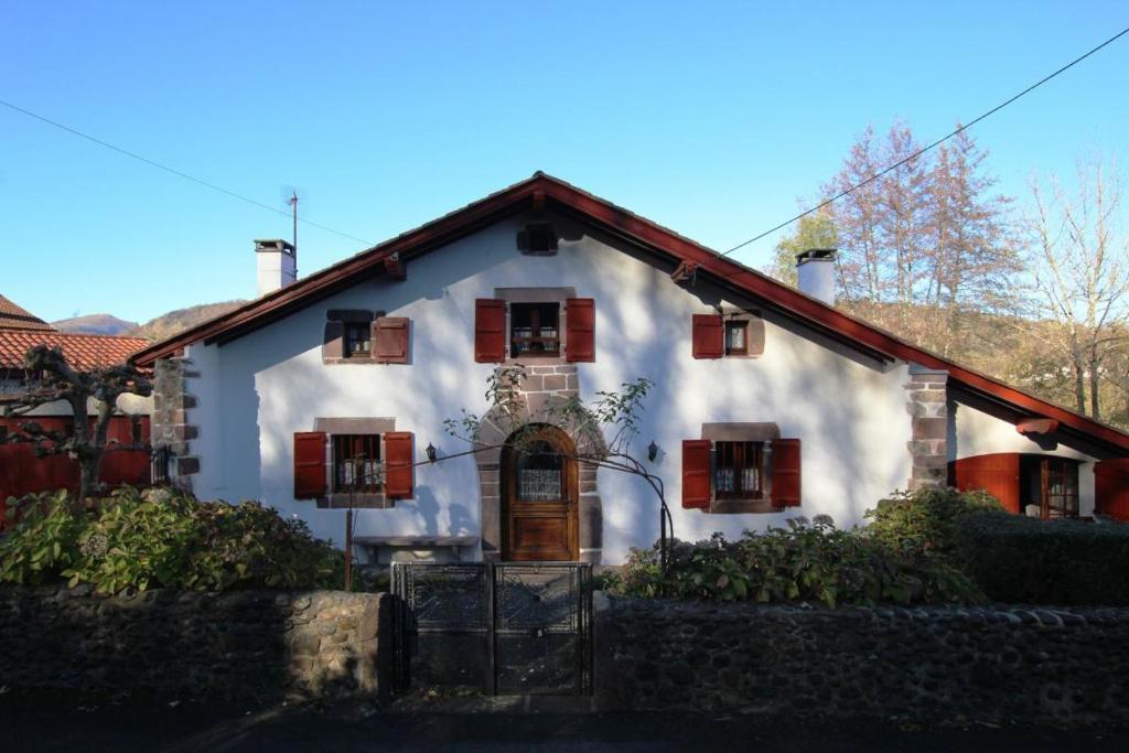 una casa blanca con ventanas con contraventanas rojas en Chez aguirre, en Saint-Jean-Pied-de-Port
