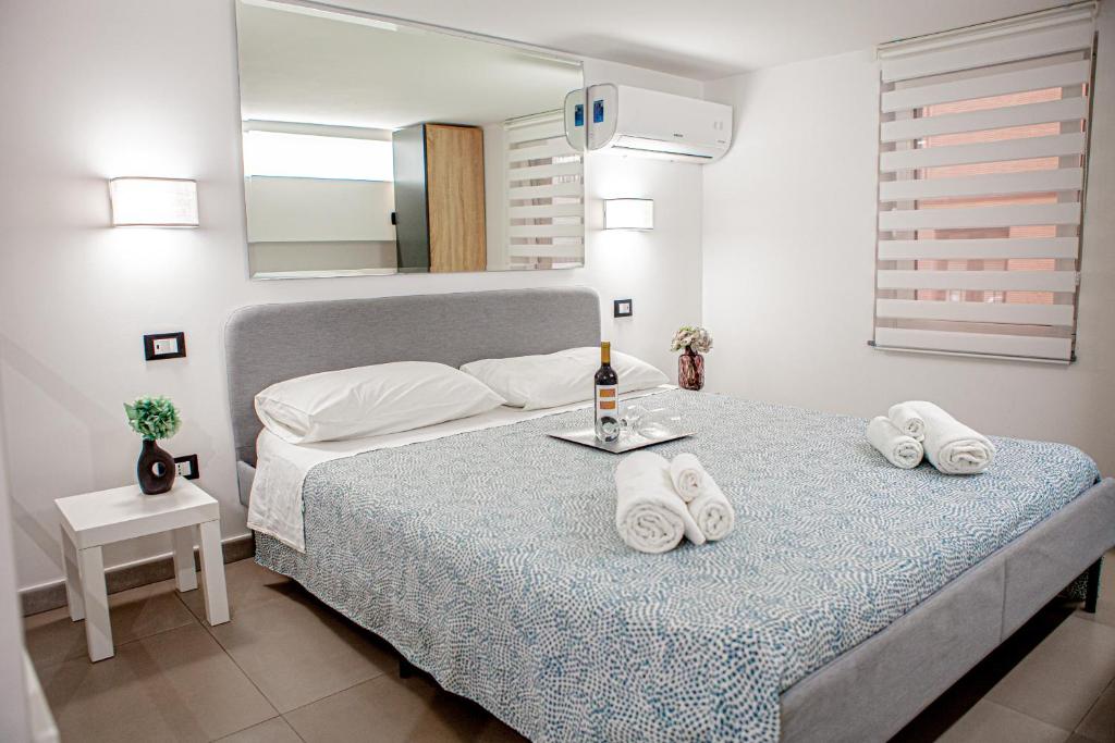 een slaapkamer met een bed met handdoeken erop bij Ruggero Settimo - Holiday Houses in Catania