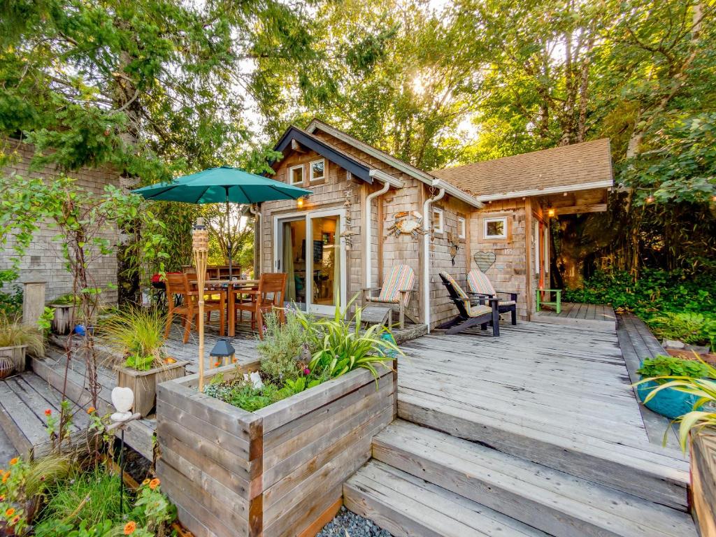 a wooden deck with an umbrella in front of a cabin at Lil Love Shack in Manzanita