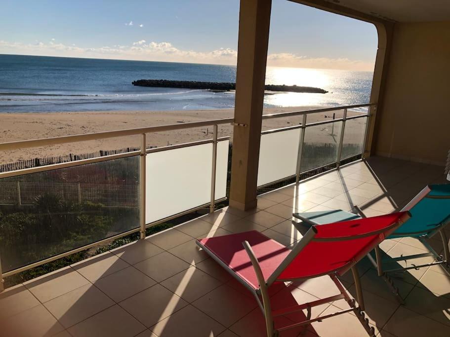a room with a balcony with a view of the beach at Appartement Front de mer in Valras-Plage