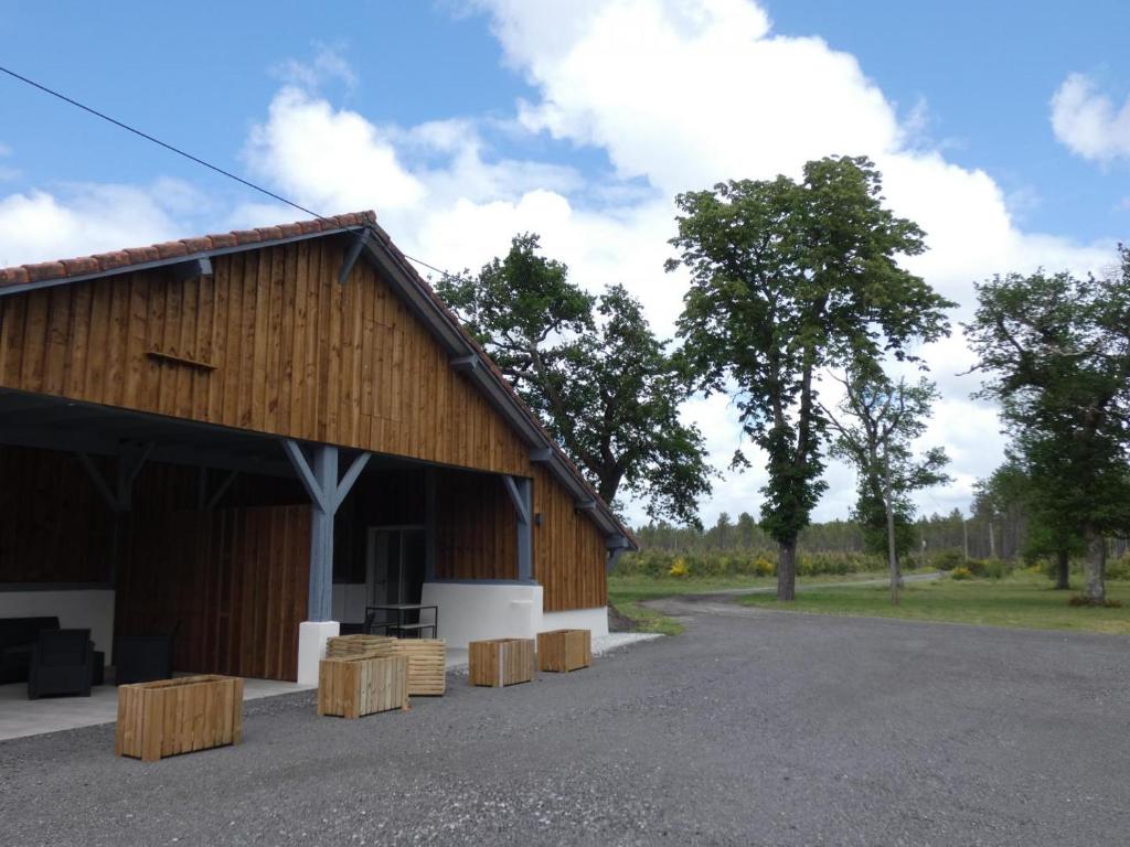 un edificio con taburetes de madera delante de él en Le clemens, en Herm