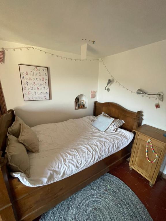 - une chambre avec un lit en bois et une table de chevet dans l'établissement Le Brocco, à Le Broc